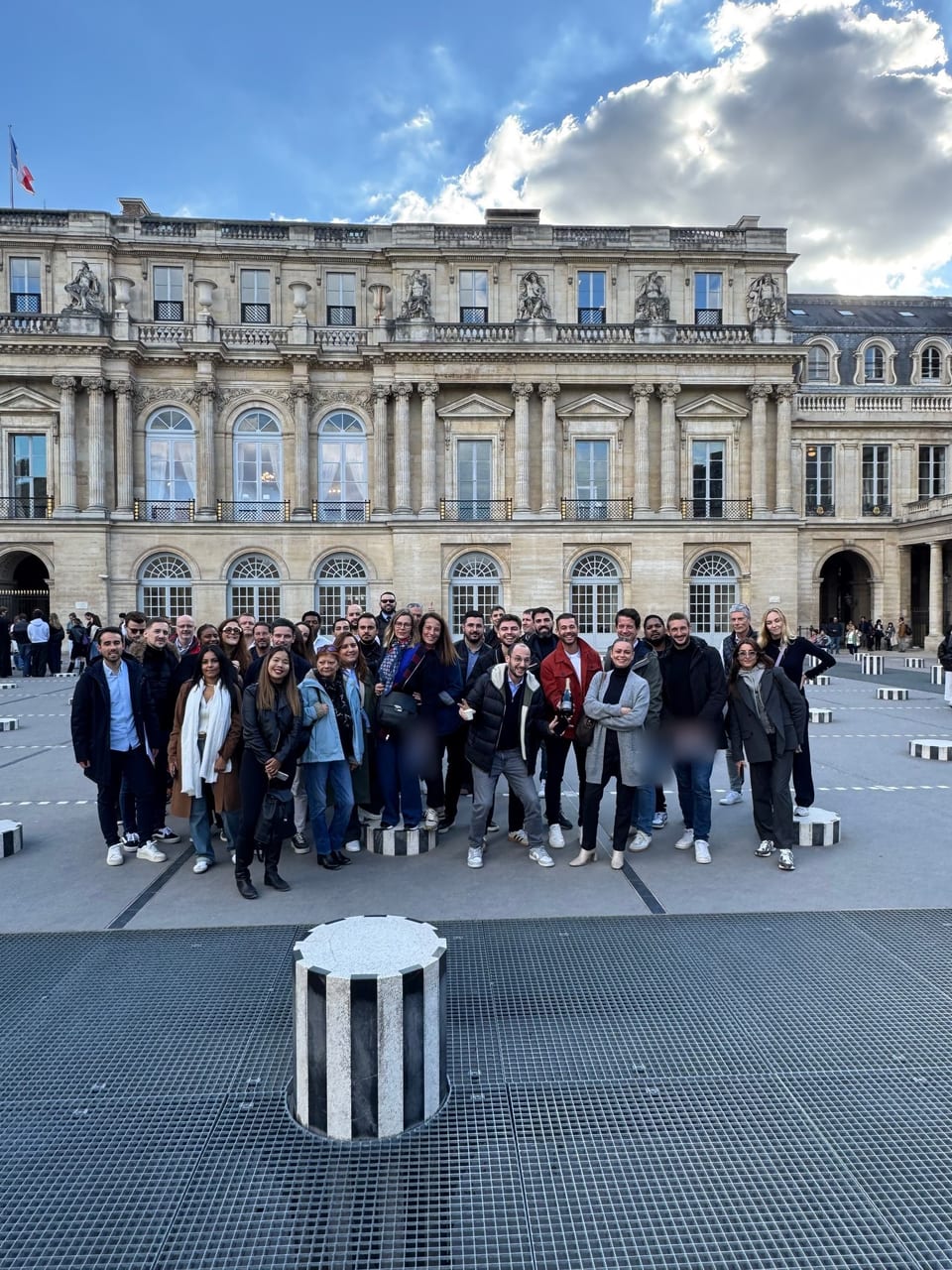 Un grand groupe de team-building devant les colonnes du Palais-Royal