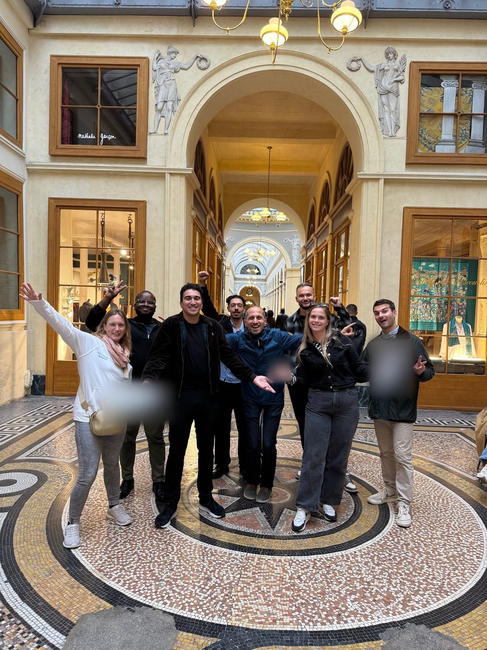 Une équipe de team-building, bras levés, dans la galerie Vivienne